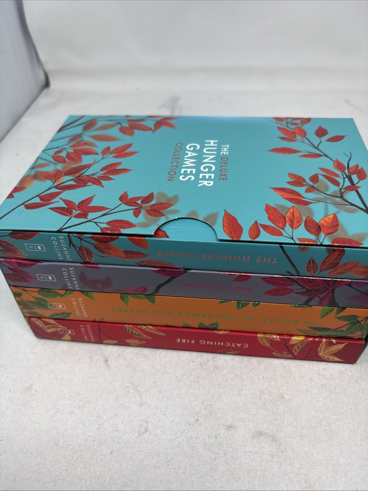 The Deluxe Hunger Games collection paperback + hard cover sunrise on the reaping